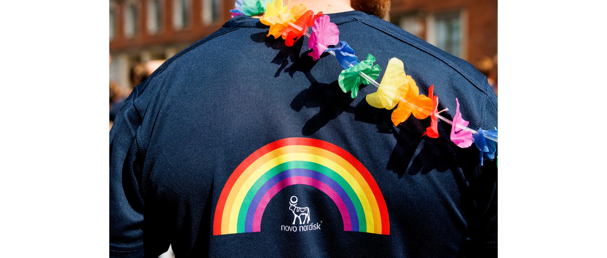 Our colleague has an LGBTQ+ rainbow above the Novo Nordisk logo on the back of his dark blue sweater